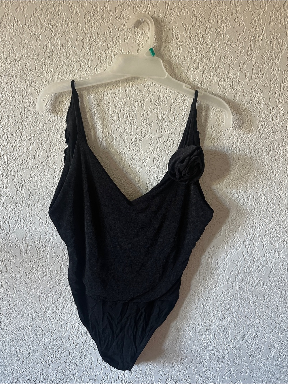 Lulu's Black Sleeveless V-Neck Bodysuit with Rosette Accent